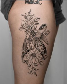 a turtle and flowers tattoo on the thigh