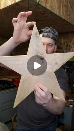 a man holding a wooden star in his hands