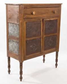 an old wooden cabinet with metal inserts on the doors and drawer drawers, sitting against a white background