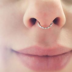 a woman's nose with a silver ring on it