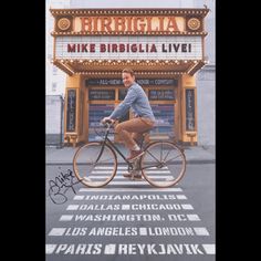 a man riding a bike in front of a movie theater