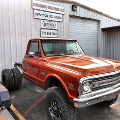 an orange truck parked in front of a building