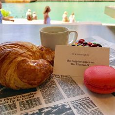 there is a croissant, coffee and doughnuts on the table next to each other