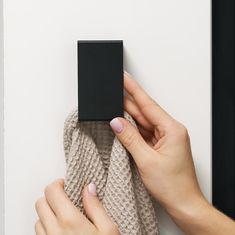 a woman is holding a black square object in her hand