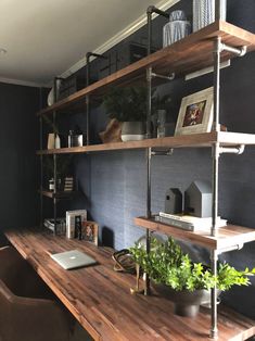 a wooden desk topped with lots of shelves filled with plants and potted greenery