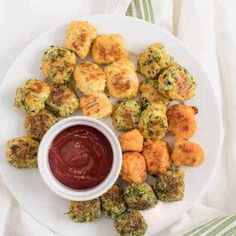 a white plate topped with tater tots next to a small bowl of ketchup