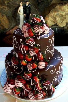 a wedding cake with chocolate frosting and strawberries on top