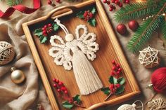 an ornament in the shape of an angel on a wooden tray surrounded by christmas decorations