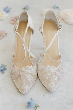 the bride's shoes are adorned with white lace and floral appliques