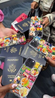 four people holding up their passport cases with food on them, and one person is holding an iphone