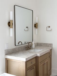 a bathroom with two sinks and a large mirror on the wall above it's counter