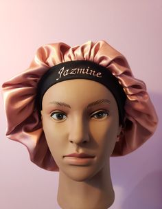 a mannequin head wearing a pink satin turban with the name jazminite on it