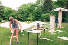 a woman in shorts and tank top playing frisbee golf on grass with umbrellas