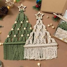 two christmas trees made out of macrame yarn and other items on a table