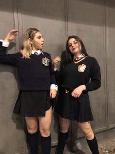 two women dressed in school uniforms posing for the camera