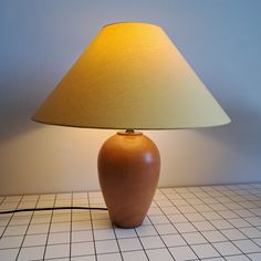 a table lamp sitting on top of a white tiled floor