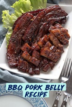 a plate with meat and lettuce on it next to a knife and fork