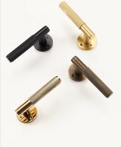 four different types of door handles and knobs on a white surface with one black handle, the other gold