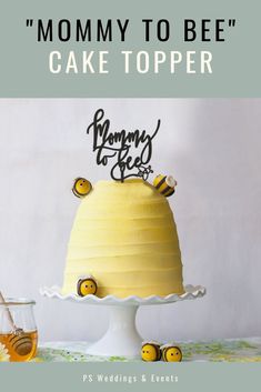 a yellow cake with bees on it and the words mommy to bee cake topper