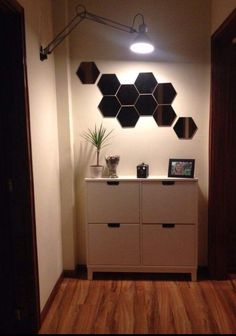 a white cabinet with some plants on top of it in a room that has wood floors