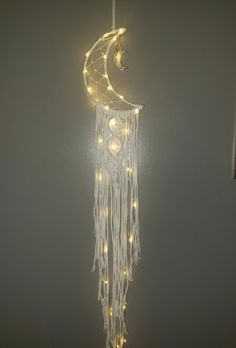 a white string light hanging from the side of a wall with a crescent and stars on it