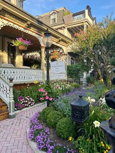 a garden with flowers and plants in front of a house