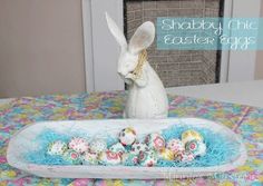 an easter basket with painted eggs in it and a white bunny sitting next to it