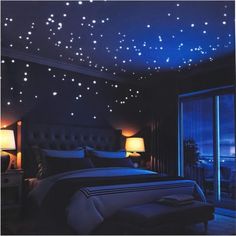 a bed room with a neatly made bed and stars on the ceiling