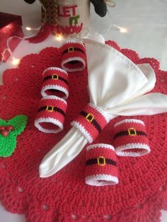 a crocheted table cloth with santa's hats and napkins on it