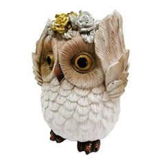 an owl figurine with flowers on it's head is shown in front of a white background