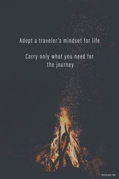 a person standing in front of a campfire with the words adopt a traveler's mindset for life carry only what you need for the journey