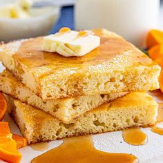 three pieces of cake sitting on top of a white plate next to sliced oranges