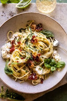 a white bowl filled with pasta and spinach