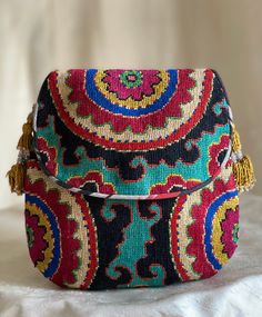 "Smallish size Flat with Flap Silk Petit Point Handbag created and handmade in Uzbekistan. Lined with silk and cotton stripe fabric, hand woven silk straps and tassels with a magnetic snap closure. Each handbag is hand drawn onto cotton canvas, inspired by original designs from Uzbekistan textile history.  8\" high x 7.5\" width, top opening 6\" wide approx. 60\" strap x 3/8\" width.  Can fit largest sizes of iPhone and Android. 100% silk petit point with handwoven silk ikat lining. I can shorte Multicolor Handwork Pouch Shoulder Bag, Traditional Multicolor Bag With Removable Pouch, Traditional Multicolor Bags With Removable Pouch, Artisan Multicolor Shoulder Bag With Removable Pouch, Traditional Pouch Bag With Multicolor Embroidery, Traditional Multicolor Embroidered Shoulder Bag For Travel, Traditional Multicolor Embroidered Pouch Bag, Traditional Multicolor Shoulder Bag With Removable Pouch, Artisan Embroidered Pouch Bag