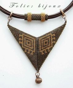 the beaded triangle necklace is hanging from a leather cord