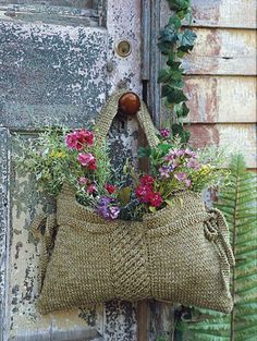 a bag with flowers hanging from it's side and a quote on the front