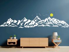 a mountain range wall decal in a living room with a table and sideboard