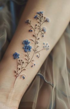 a woman's foot with blue flowers on it and the bottom part of her leg