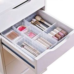 an open drawer with makeup and brushes in it