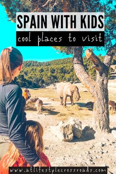 a woman and child looking at elephants in the distance with text overlay that reads spain with kids cool places to visit