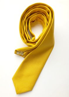 DESCRIPTION: This lovely men's skinny tie has been handmade using a gorgeous vibrant mustard yellow canvas, with a floral lining. FABRIC: Lightweight duck canvas (similar to a medium linen or heavy cotton) LINING FABRIC: Cotton. -------------------------------------------------------------------------------------------- DETAILS: * Made the traditional way with fabric cut on the bias * Each tie has canvas lining throughout * Fabric lining just at the tip on each end of the tie * Width at the wide Yellow Summer Ties, Yellow Summer Business Ties, Classic Yellow Tie For Formal Occasions, Yellow Classic Ties For Summer, Classic Yellow Ties For Summer, Yellow Suit And Tie Accessories For Black Tie Event, Formal Yellow Tie, Classic Yellow Wedding Tie, Yellow Tie Wedding