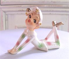 a small figurine sitting on top of a white table next to a mirror