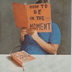 a man sitting at a table reading a book with the words how to be in the moment