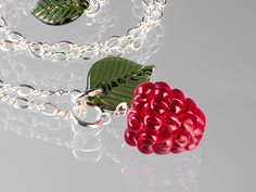 Glass Raspberry Necklace features one of my handmade glass raspberry beads with a separate green transparent glass leaf. The raspberry i s life-sized (just over 5/8 inches high).   They are hung on rings and suspended from an ADJUSTABLE length figure-8 chain in Sterling Silver or 14/20 Gold-filled. The chain will be either 20 or 30 inches overall, but you can wear it at any length you please by clipping the lobster clasp into the link of your choice. The free end of the chain is decorated with a Raspberry Necklace, Melting Glass, Fruit Necklace, Monday December, Fruit Jewelry, Boulder Co, Paper Gift Box, Plant Fibres, Packing Tape