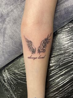 a tattoo on the leg of a woman with an angel and rose in her hand