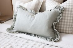 a white bed topped with lots of pillows