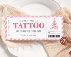 a pink and white ticket sitting on top of a plate