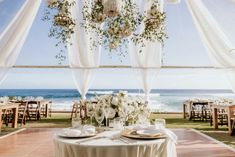 the table is set for an elegant dinner by the ocean