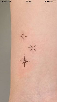 three stars tattoo on the left side of the arm, and an arrow in the middle