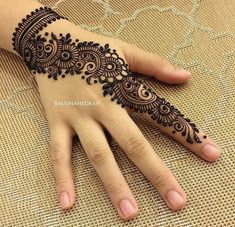 a woman's hand with henna tattoos on it